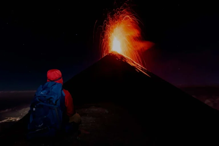 Hiker watching Volcán de Fuego erupt at night from Acatenango